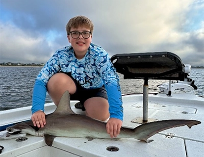 Kids catching a shark on family-friendly charter