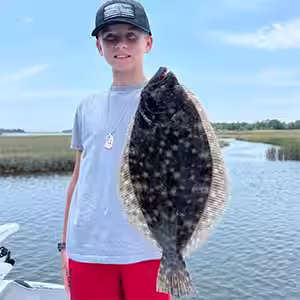 Young angler holding a flounder caught in OIB in June 2026
