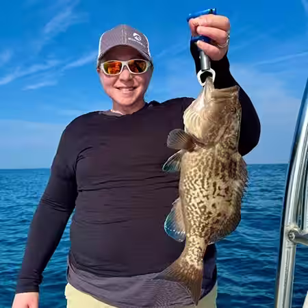 Gag Grouper held by female angler near Dale Ward Reef in NC