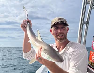 Book a nearshore fishing charter in Ocean Isle Beach today! Angler holding a sharpnose shark caught nearshore from Ocean Isle Beach NC