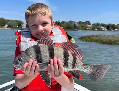 Young boy holding a black drum caught in Ocean Isle Beach NC